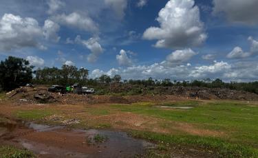 Image of piles of green waste with cars and trailers at Archer Waste Management Facility