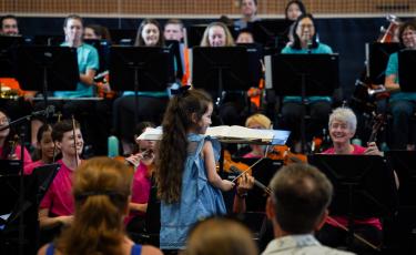 Image: Small girl conducting Orchestra