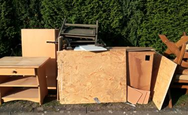 Wooden side table, chairs, and other furniture placed on the verge for Palmerston’s pre-cyclone clean-up collection