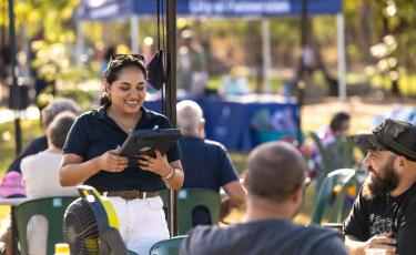 Image: staff talking to communtiy with ipad 
