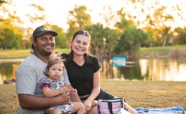 parents and a small child with Sanctuary Lakes in the background