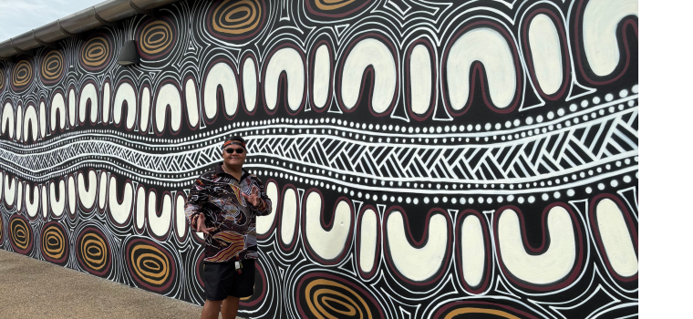 Image of RAP Mural with artist William Hewitt standing in front